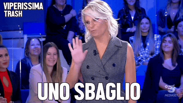 a woman waves her hand in front of a crowd with the words uno sbaglio written above her