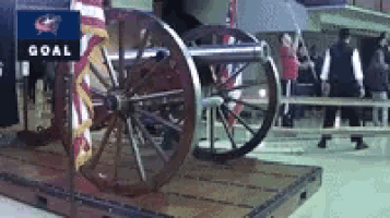 a cannon is on display in front of a goal banner