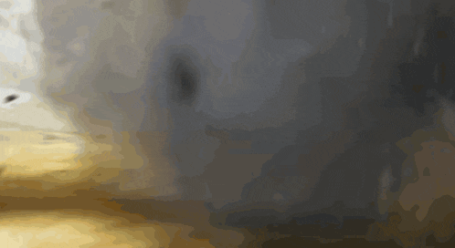 a blurred image of a person standing in front of a black wall