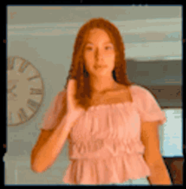 a woman in a pink top is giving a thumbs up sign .