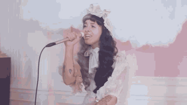 a woman is singing into a microphone while wearing a headband .