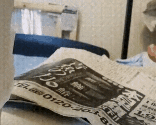 a person is reading a newspaper with the number 0120-204 on it