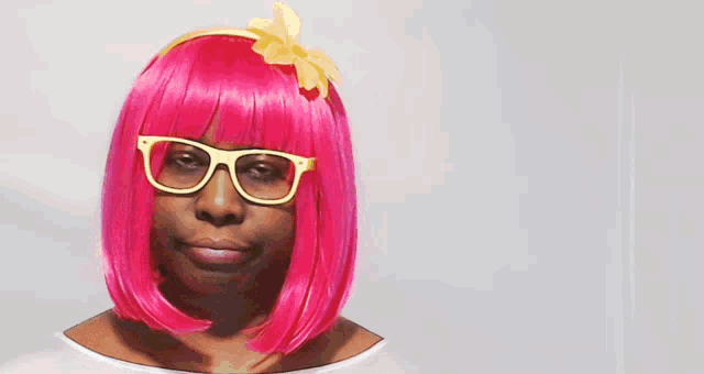 a woman in a pink wig and glasses holds a sign that says hate that