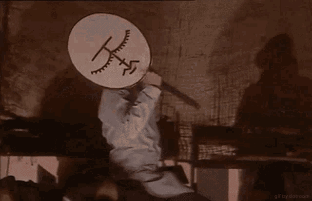 a person is holding a circle with a drawing of a cross on it