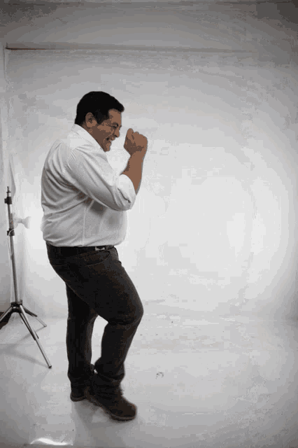 a man in a white shirt and black pants is dancing
