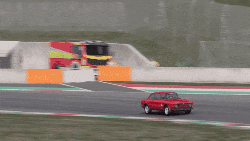 a red car with the letter a on the side is driving down a track