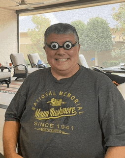 a man wearing glasses and a national memorial shirt