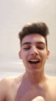 a young man without a shirt is smiling with his mouth open
