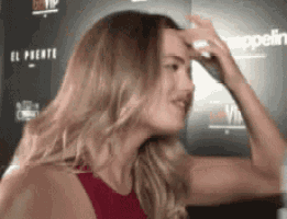 a woman in a red dress is touching her forehead