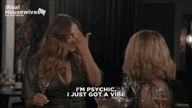two women are sitting at a table and one of them is saying " i 'm psychic "