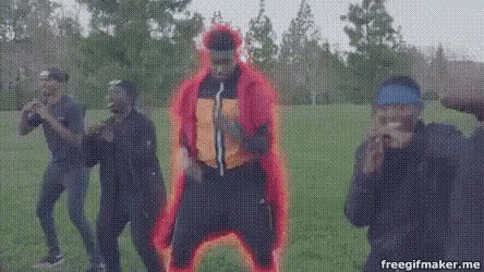 a group of men are dancing in a park and one of them is wearing a red cape