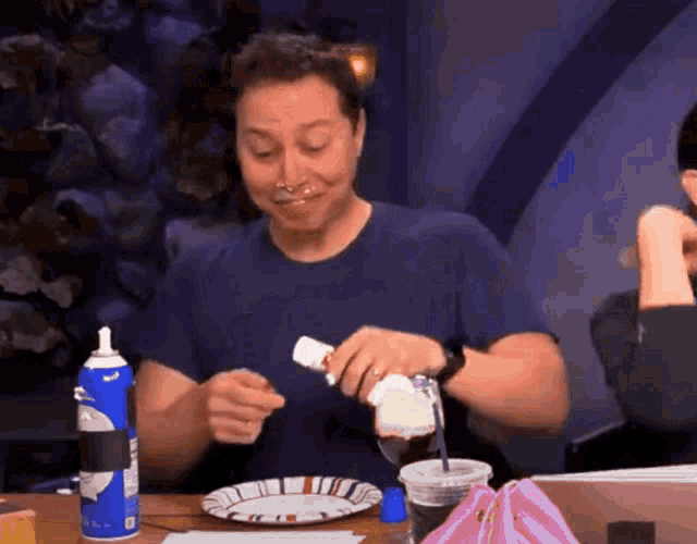 a man is pouring whipped cream into a drink