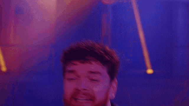 a blurry picture of a man with a beard dancing in a dark room