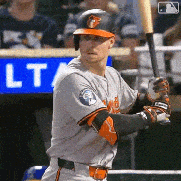a baseball player holds a bat in front of a sign that says lt