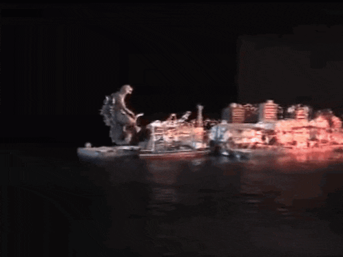 a statue of a monster standing on top of a boat in the water