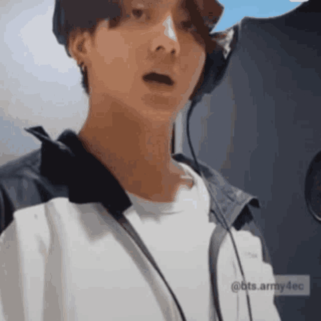 a close up of a person wearing headphones and a jacket