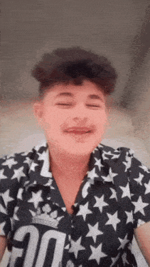 a young boy wearing a black and white shirt with stars and the number 20 on it