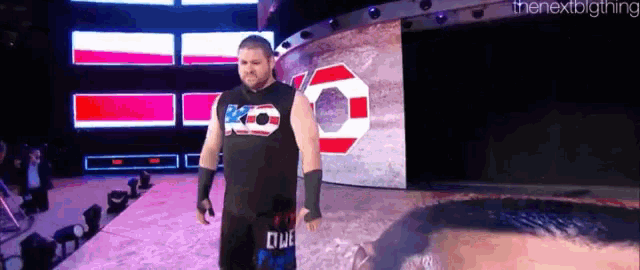 a wrestler is walking on a stage wearing a shirt that says ko .