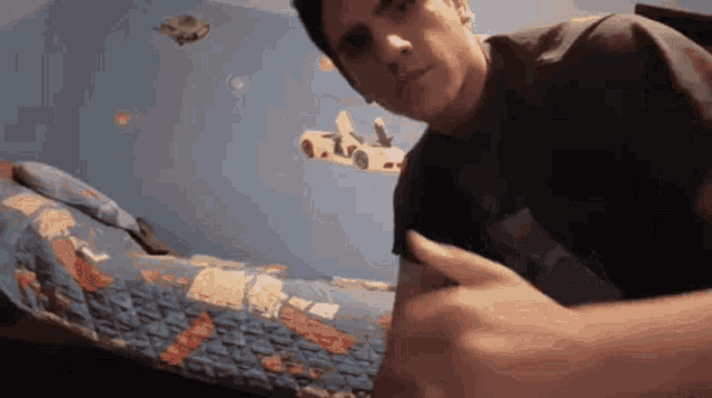 a man in a black shirt is pointing at his arm