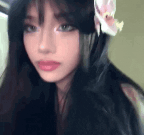 a girl with long black hair and a flower in her hair .