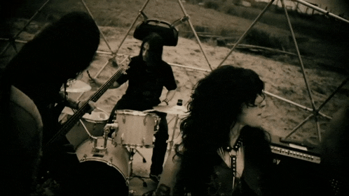 a man in a pirate hat is playing drums in a black and white photo