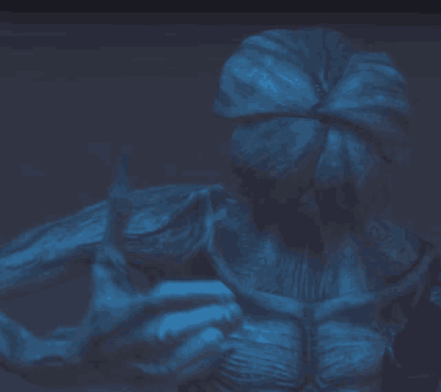 a statue of a monster with a flower on its head giving a thumbs up