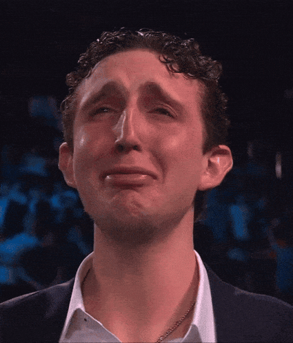 a man in a suit and white shirt is making a sad face
