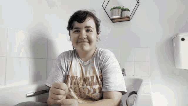 a woman in a bathtub wearing a tie dye shirt that says rvca on it