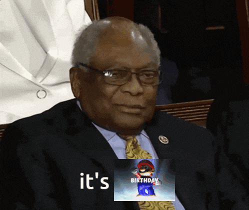 a man in a suit and tie is holding a picture of mario and the words " it 's birthday "
