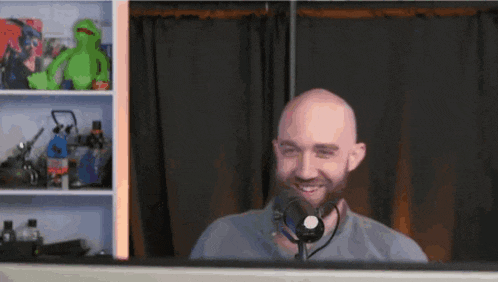 a bald man with a beard is wearing a headset