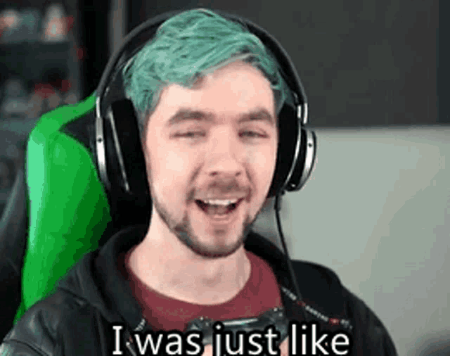 a man with green hair and headphones is sitting in a green chair and smiling .