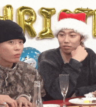 a man in a santa hat sits at a table