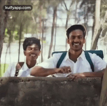 two men are standing next to each other and smiling .