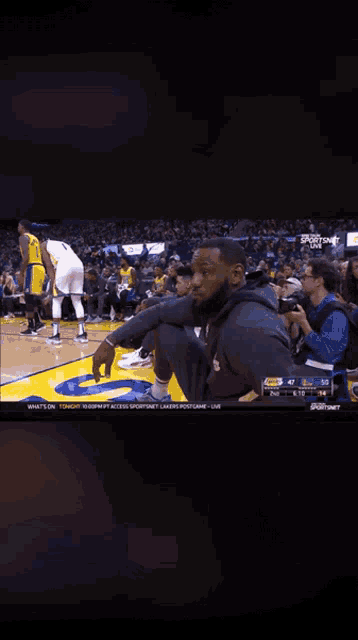 lebron james sits on the court during a game