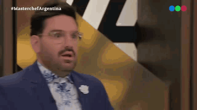 a man wearing glasses and a suit is on a tv show called masterchef argentina