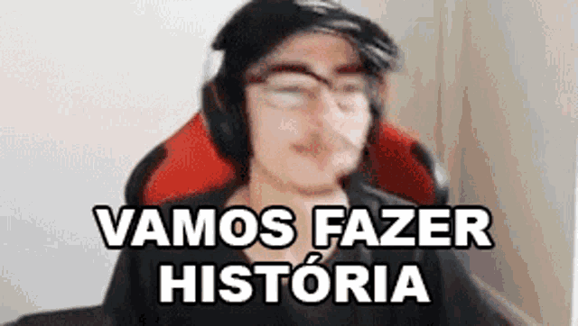 a man wearing headphones and glasses is sitting in a chair with the words `` vamos fazer historia '' .