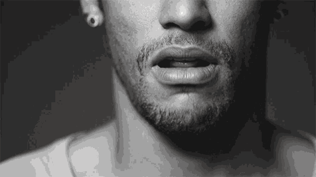 a close up of a man 's face with a beard and earrings