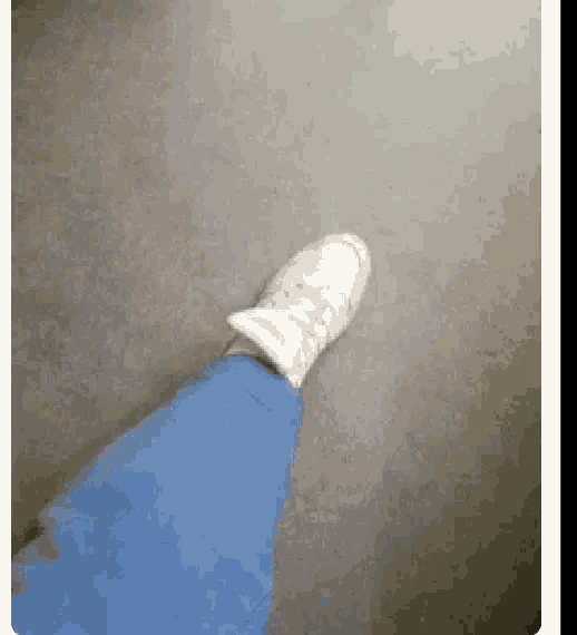 a person wearing blue jeans and white sneakers is walking on the floor