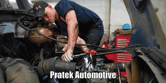 a man is working on the engine of a truck with the words pratek automotive written below him