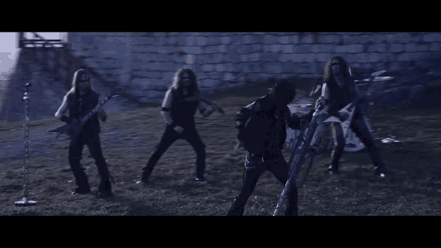 a group of men are standing in a field playing guitars