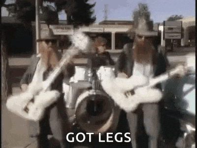 a group of men playing guitars and drums on a sidewalk .