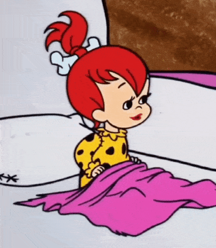 a little girl with red hair is sitting under a pink blanket