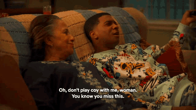 a man and woman are laying on a couch and the woman is saying oh don t play coy with me woman