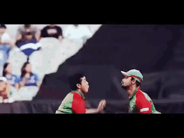 two cricket players are standing next to each other on a field .