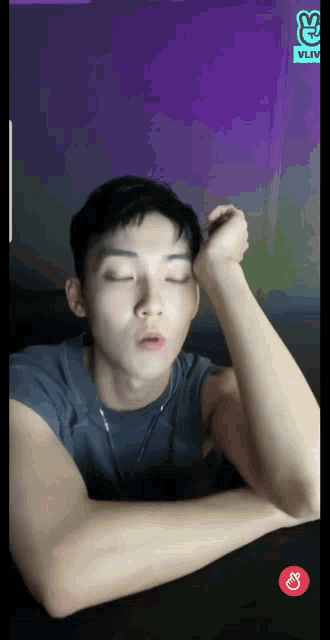 a man with his eyes closed is sitting in front of a vlive logo