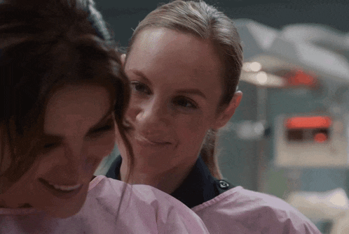 a woman in a pink gown is smiling next to another woman