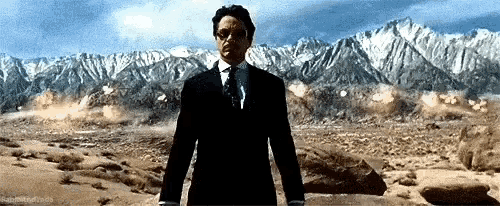 a man in a suit and tie is standing in the desert