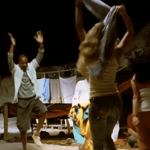 a man and a woman are dancing in front of a clothes line