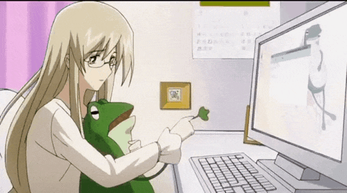 a woman is holding a frog and pointing at a computer screen