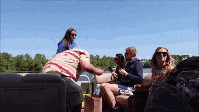 a group of people are sitting on a boat and one of them is wearing sunglasses